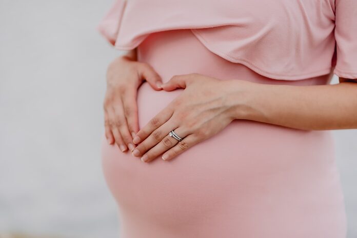 skincare-routine-femme-enceinte-trimestre-par-trimestre woman wearing gold ring and pink dress